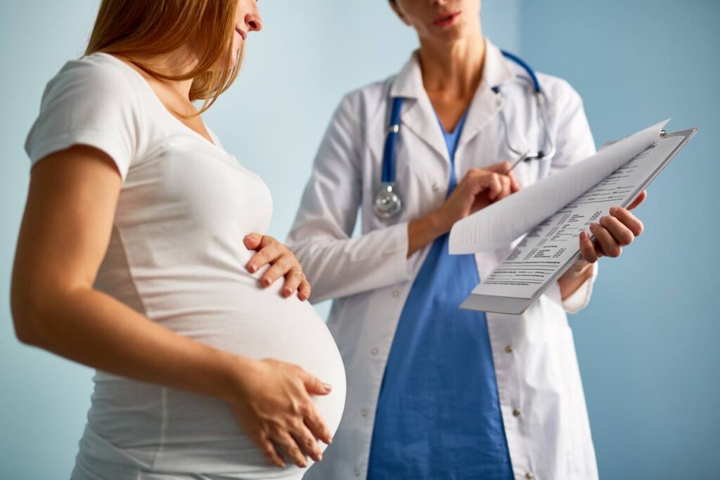 medico mostra a una donna incinta il calcolo della data presunta del parto