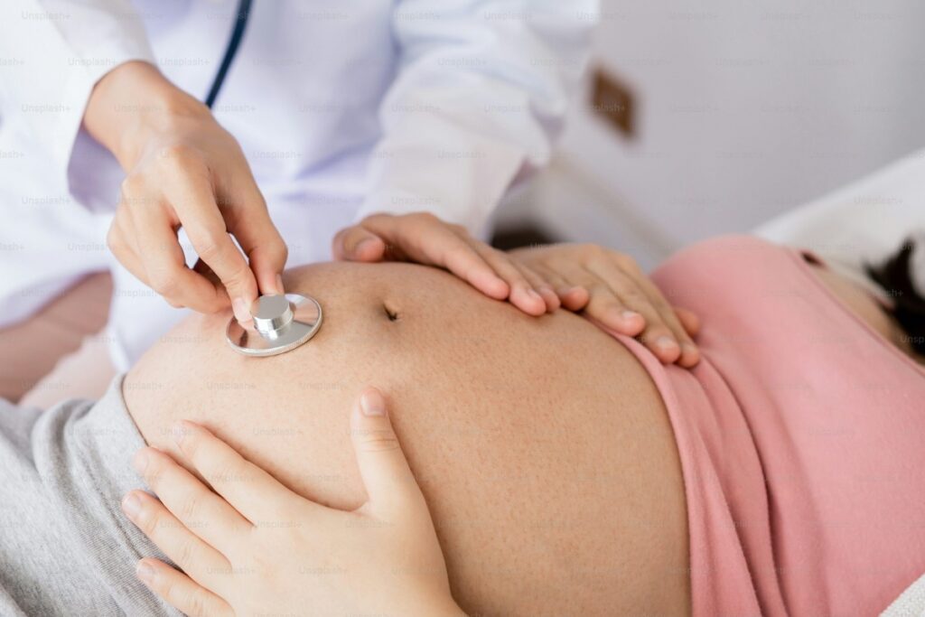 medico esamina la pancia di una donna incinta